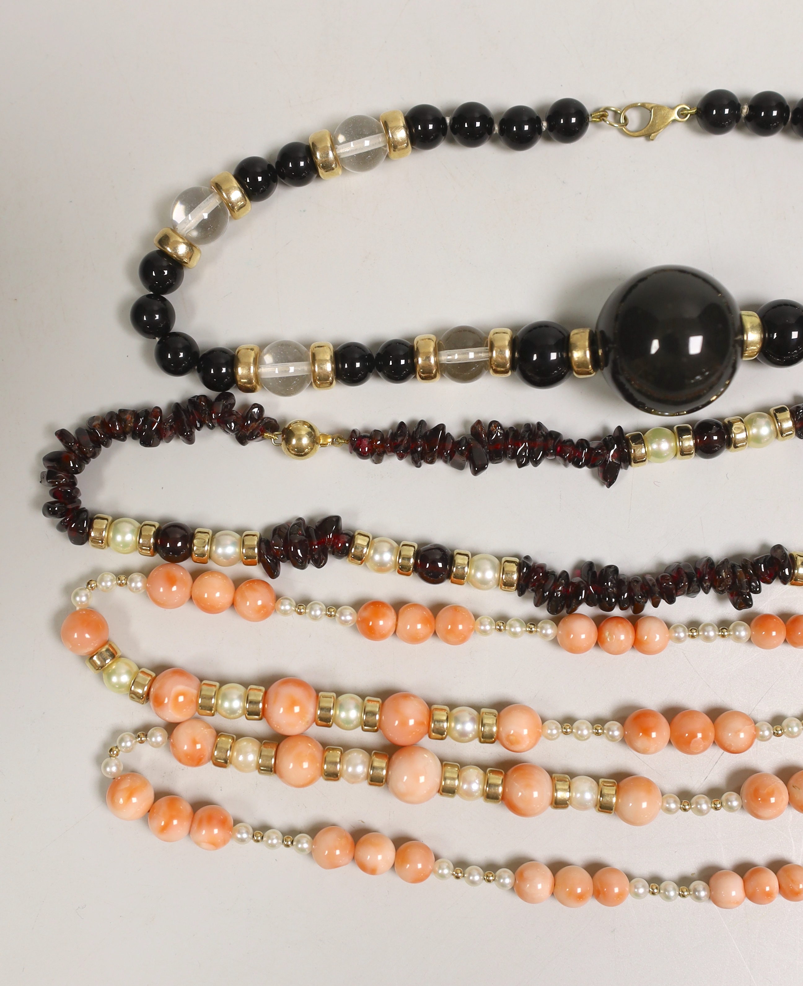 A modern garnet and cultured pearl necklace with yellow metal spacers and clasp, 48cm and three other necklaces.